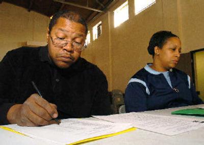 Antonio Brooks, 39, left, and his wife Enie Brooks, 40, fill out paperwork and attend a Forclosure Prevention workshop in Edgewater, Co., last week. The couple are on the edge of foreclosure according to Enie Brooks
 (Associated Press / The Spokesman-Review)