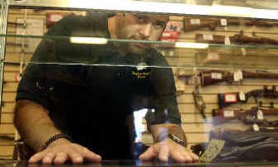 
Ken Craudell, manager of Double Eagle Pawn Shop, looks out of an empty case that contained handguns stolen by the burglars. A row of rifles from the back wall of the store was also taken.
 (Kathryn Stevens / The Spokesman-Review)