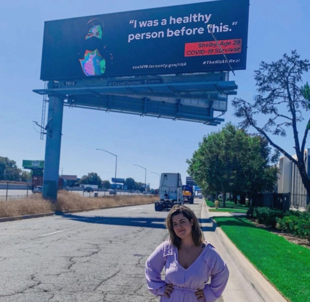 Shelby Hedgecock stands in front of a billboard from a Los Angeles County public health campaign that features her as a long COVID patient.    (Gustavo Sosa/KFF Health News/TNS)
