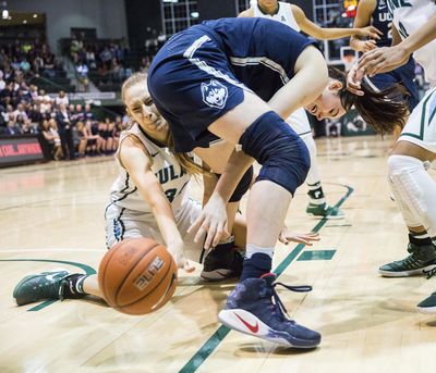 Tulane center Ksenija Madzarevic (left) and Conneticut's Natalie Butler (center) fight for possession during the Huskies’ 63-60 win on Saturday. (Sophia Germer / Associated Press)
