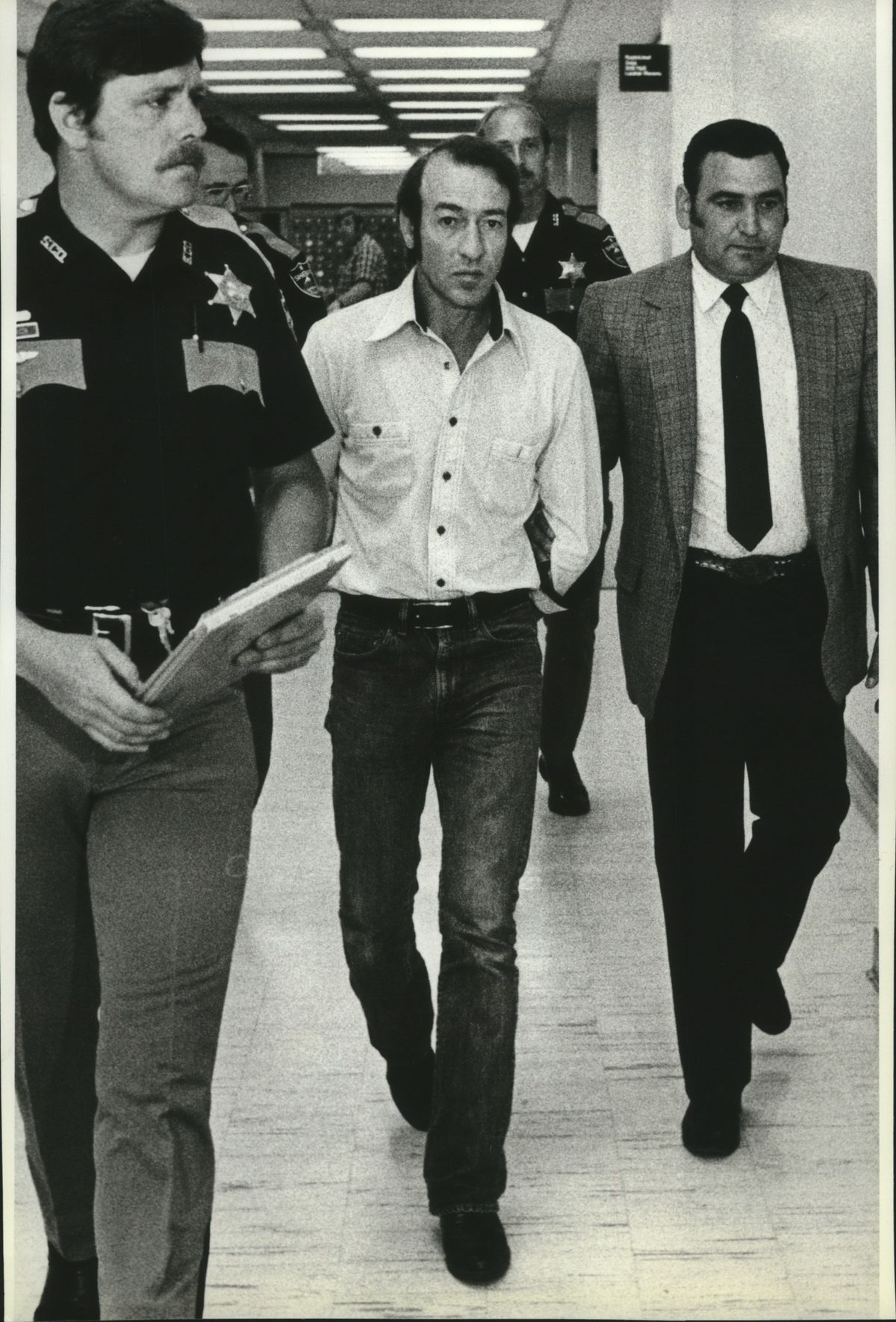 Arbie Williams, kidnapping suspect escorted by Sheriff Mike Massong, is shown in this 1983 photo. (Cowles Publishing)