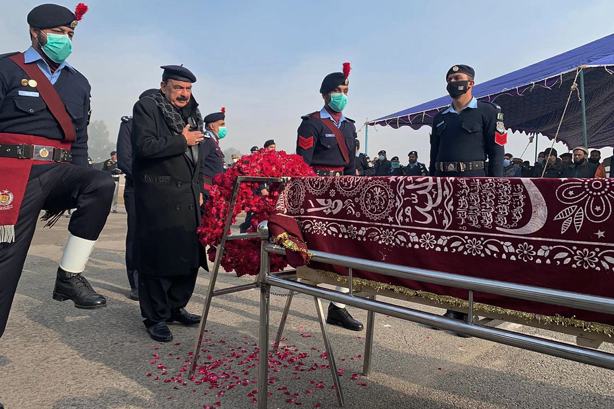 Pakistani Interior Minister Sheikh Rashid Ahmed, second left, pays tribute to a police officer, who was killed in an overnight attack, at a funeral prayer, in Islamabad, Pakistan, Tuesday, Jan. 18, 2022. The Pakistani Taliban targeted police in multiple attacks in Islamabad and elsewhere in the country