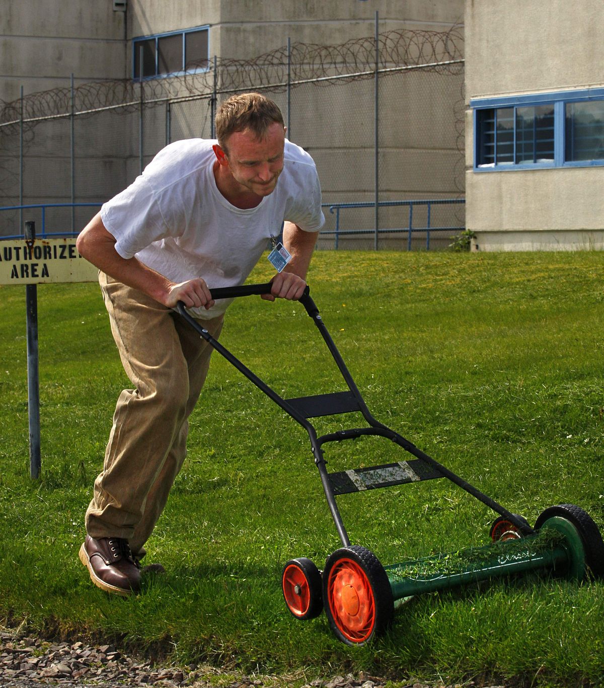 Tony Turner, 28, works up a sweat  Monday mowing the lawn with a push mower inside the Monroe Correctional Complex.