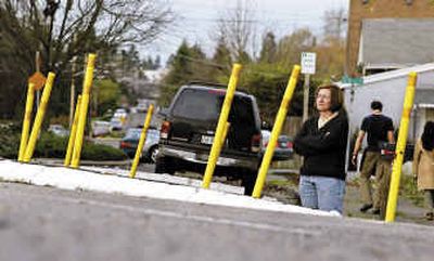 
Kate Martin, an activist for Seattle's Greenwood neighborhood, stands on the side of Palatine Avenue North to show how high the street buckles in the middle, the result of changing groundwater conditions. 
 (Associated Press / The Spokesman-Review)