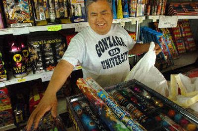 
David Comer, a partner in Two Vets Fireworks on U.S. Highway 95 near the Coeur d'Alene Casino, jokes with customers Saturday while filling orders.
 (Jesse Tinsley / The Spokesman-Review)