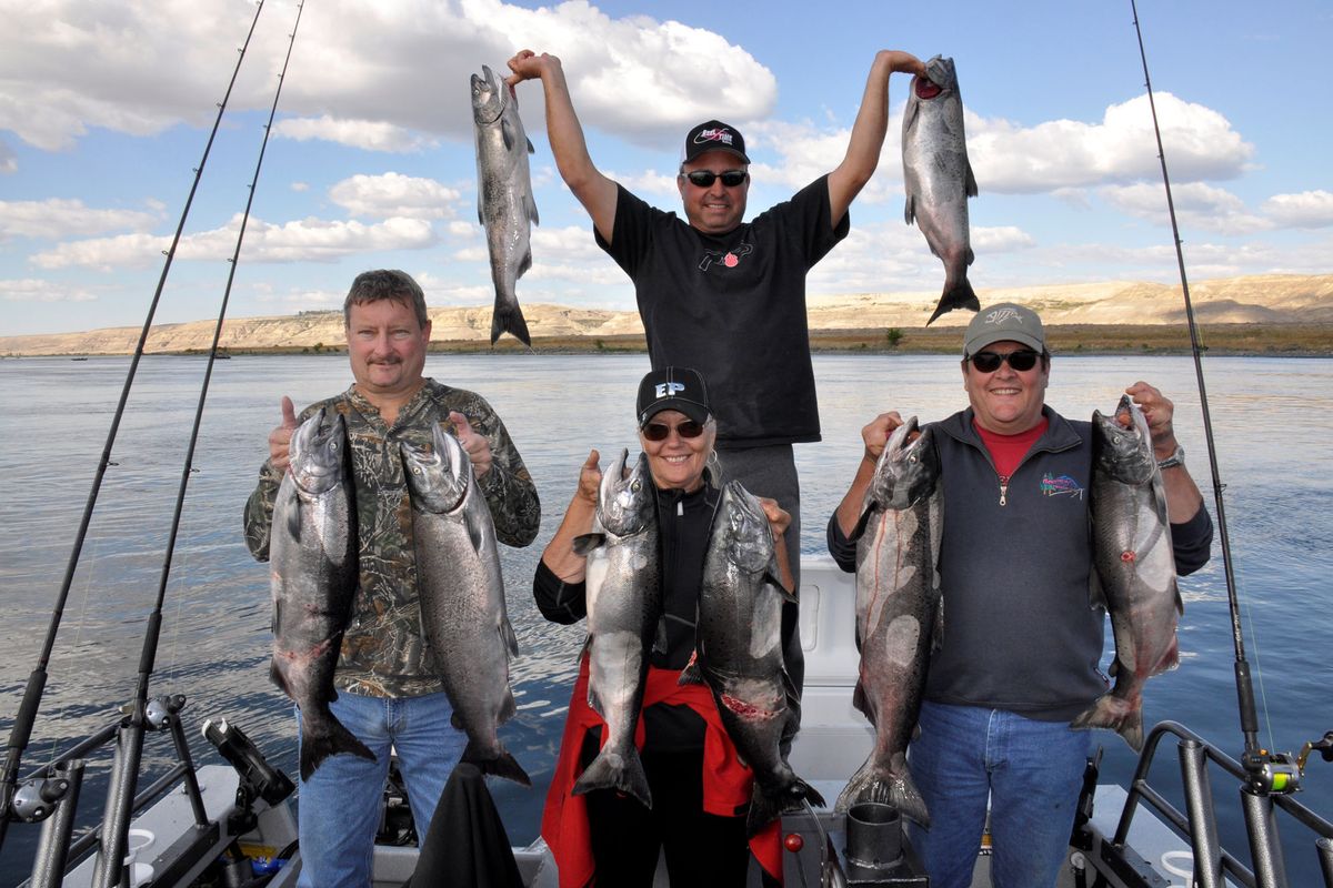 Guide Toby Wyatt, top, celebrates a good day of Chinook salmon fishing with clients, from left, John Dick and Gloria and Kim Bowman. (Rich Landers)