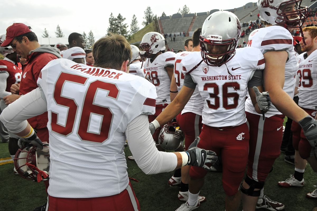 Washington State University players Anthony Hammock (56) and Matthew Simmons slap five at mid-field after the WSU spring scrimmage, April 16, 2011, at Joe Albi Stadium in Spokane, Wash. (Dan Pelle / The Spokesman-Review)