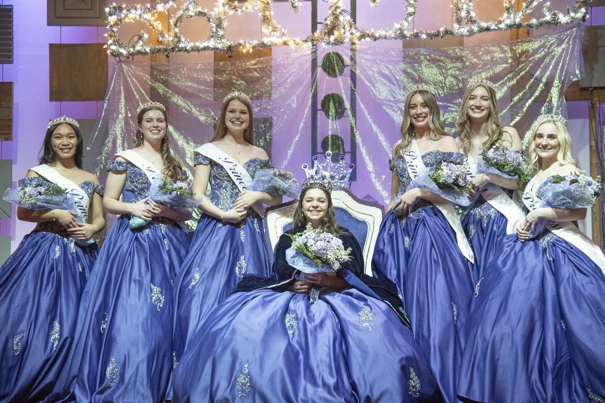 Janna Huber takes the throne after donning the tiara and cape of the Lilac Festival Queen and poses for pictures with the other six princesses: from left, Velerie Dancel; Megan Tallman; Taryn Frerichs; Ryan Ham; Shelby Zehm and Ella Hilliard, Saturday, Mar. 26, 2022 at First Church in north Spokane, the site of the Lilac Festival coronation program. Huber was chosen from seven princesses selected for the Lilac Festival court. She and the six other princesses will serve as ambassadors of the city and attend events and ride in parades.  (Jesse Tinsley/The Spokesman-Review)