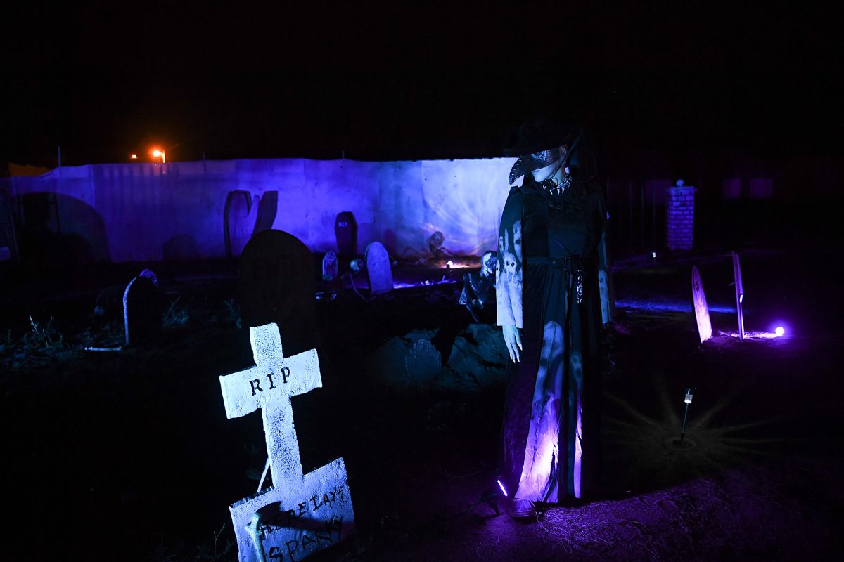 Ashley Montgomery poses for a photo in a graveyard scene at Fear in the Headlights, a drive-through haunted experience on Thursday, October 1, 2020, at 5978 WA-291 in Nine Mile Falls, Wash. Fear in the Headlights is a haunted house experience that patrons can drive their cars through. Cars move from scene to scene; once stopped and the engine is off, actors begin acting out spooky skits.  (Tyler Tjomsland/THE SPOKESMAN-REVIEW)