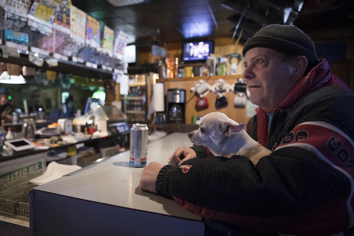 Norman Warner and his dog, Little Paw, watch sports on a nearby TV, Sunday, Nov. 19, 2017, at Moezy Inn Tavern, one of two remaining taverns on North Monroe Street. The neighborhood beer-and-wine pubs have been decreasing while liquor bars have been increasing in recent years. (Jesse Tinsley / The Spokesman-Review)
