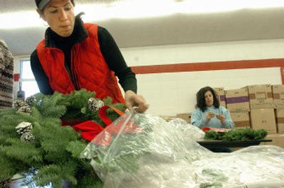 
Marina Green, left, packages a prepared wreath for the annual Canfield Middle School wreath sale Wednesday at the school as Ann Wyttree works in the background. 
 (Photos by Jesse Tinsley/ / The Spokesman-Review)