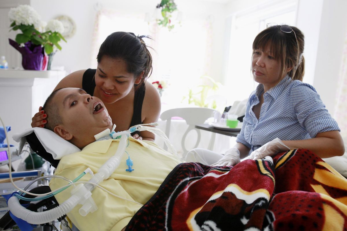Malerie Briseno, 22, left, talks to her brother, 27-year-old Joseph “Jay” Briseno Jr., as their mother, Eva Briseno, watches at their home in Manassas Park, Va., last month.  Associated Press photos (Associated Press photos)