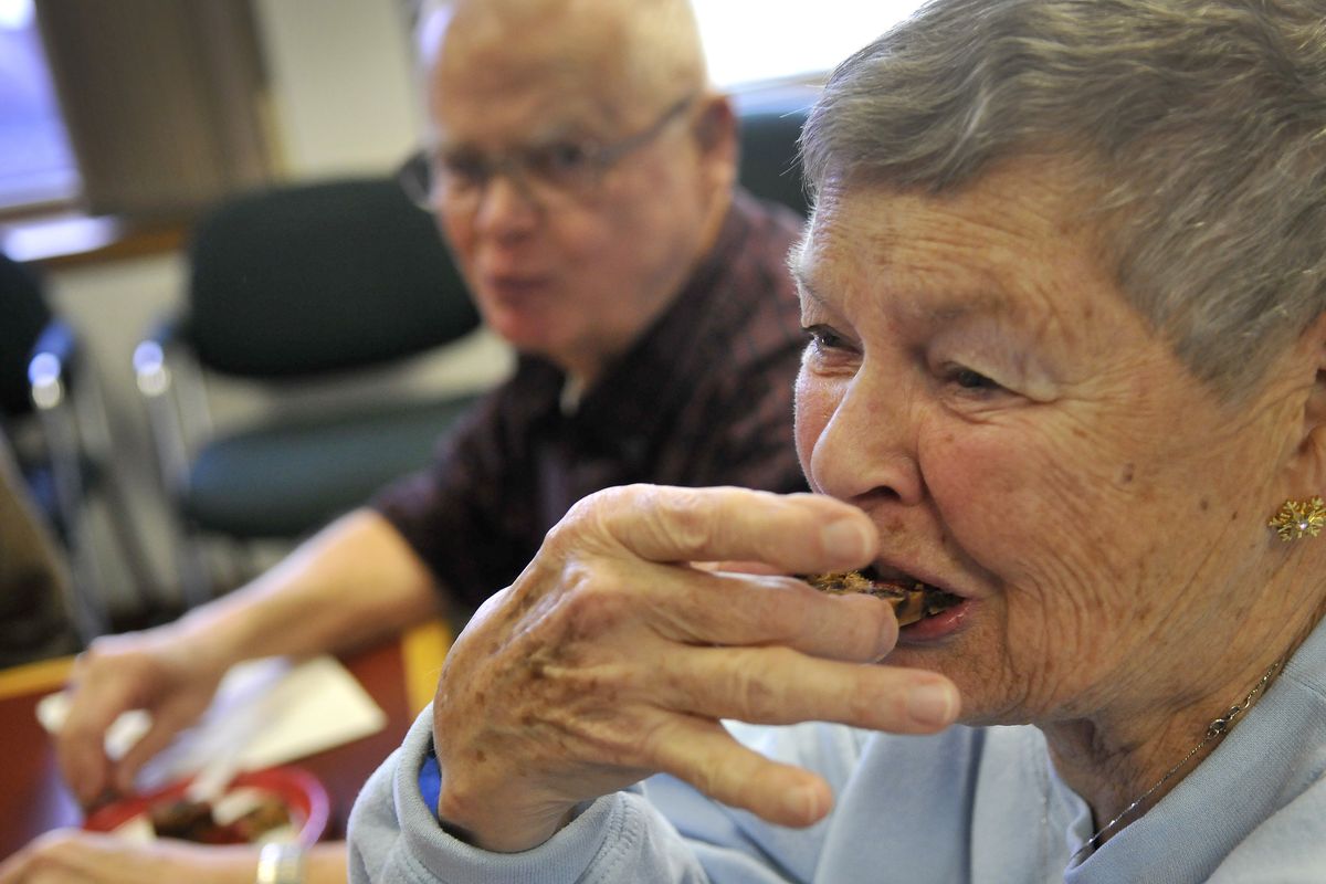 Slice reader Dee Hargitt samples a 2-year-old Hostess Holiday Fruitcake on Wednesday in The Spokesman-Review newsroom. (Colin Mulvany)