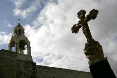 
A worshipper holds a crucifix in front of the Church of the Nativity prior to the traditional Christmas procession in Bethlehem on Saturday.
 (Associated Press / The Spokesman-Review)