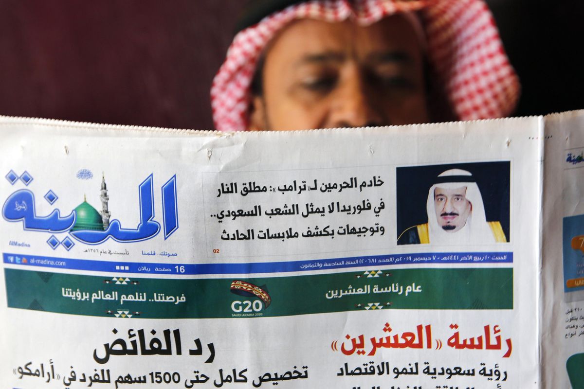 A man reads the daily Al-Madina newspaper fronted by a picture of Saudi King Salman at a coffee shop in Jiddah, Saudi Arabia, on Saturday. The top sentence reads “King Salman to Donald J. Trump: Florida shooter does not represent the Saudi people.” (Amr Nabil / Associated Press)