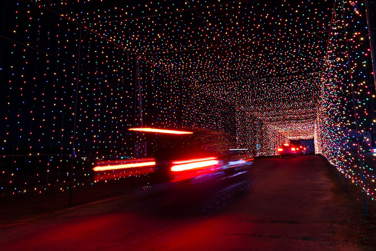Passenger vehicles move through a tunnel of holiday lights at a display set up at the Cumberland Fair Grounds, Tuesday, Dec. 14, 2021, in Cumberland, Maine. The holiday season has become more sparkly during the COVID-19 pandemic, with people and businesses pouring money into light shows to spread cheer.  (Robert F. Bukaty)