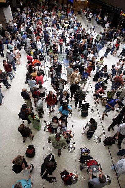 
Travelers wait to go through a security check at Sea-Tac International Airport. 
 (Associated Press / The Spokesman-Review)