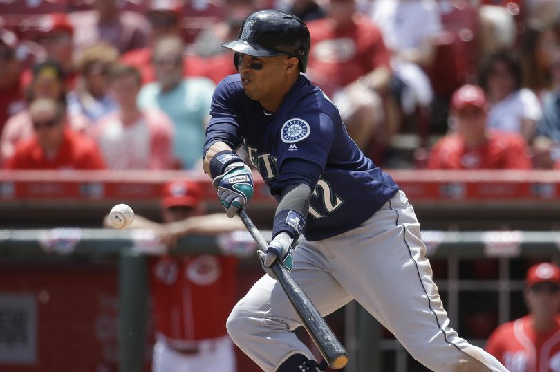 Leonys Martin of the Mariners bunts for a hit in the fifth inning. (John Minchillo / Associated Press)