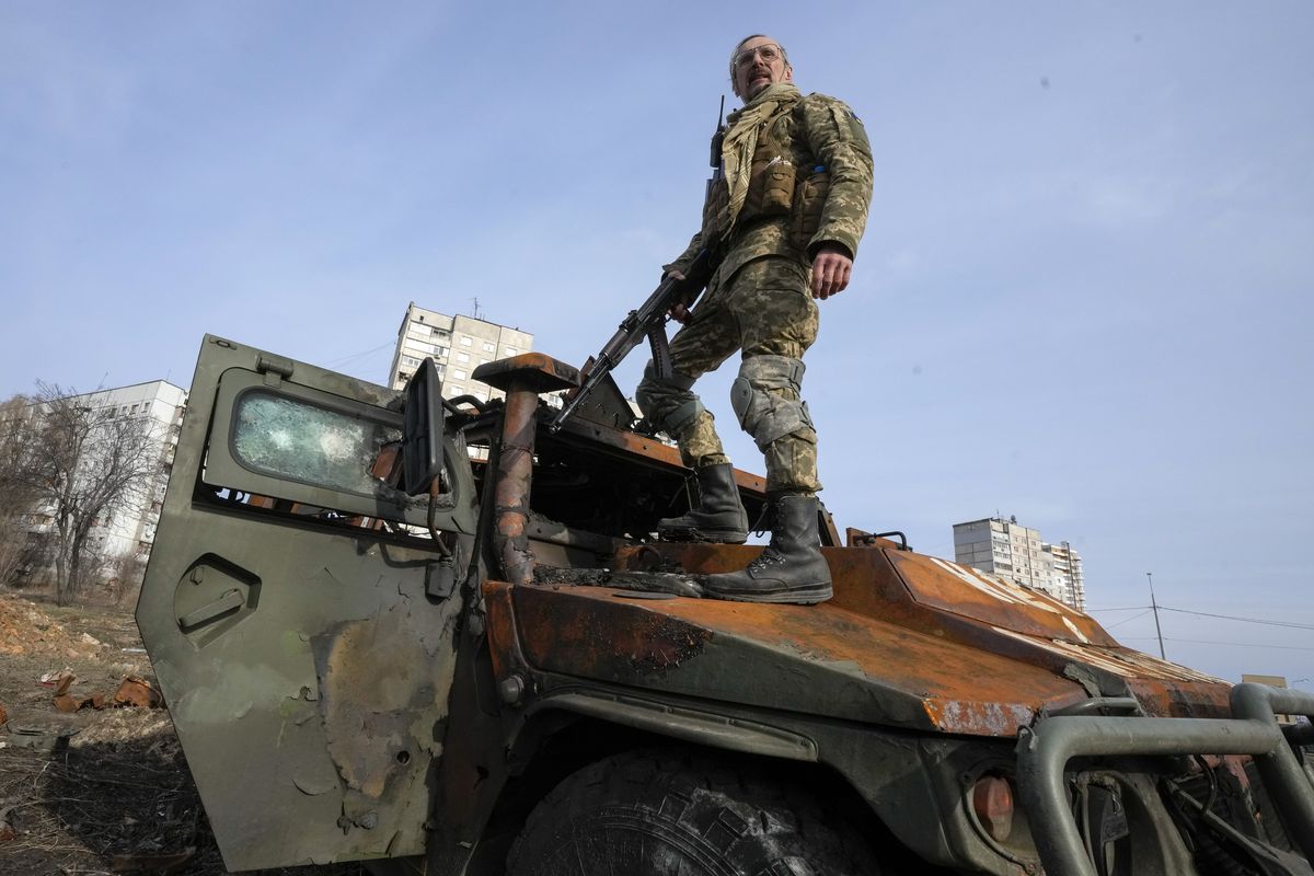 FILE - A Ukrainian soldier stands a top a destroyed Russian APC after recent battle in Kharkiv, Ukraine, on March 26, 2022. With Russia continuing to strike and encircle urban populations, from Chernihiv and Kharkiv in the north to Mariupol in the south, Ukrainian authorities said Saturday that they cannot trust statements from the Russian military Friday suggesting that the Kremlin planned to concentrate its remaining strength on wresting the entirety of Ukraine