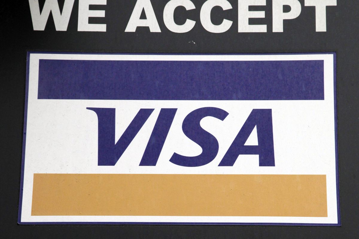 In this Jan. 21, 2015 photo, a sign indicating Visa credit cards are accepted is posted at a New York business. Payment processing giant Visa is launching a platform to allow banks to integrate various types of biometrics, such as your fingerprint, face, voice, etc., into approving credit card applications and payments. It could lead to customers having to take a selfie to verify they actually made an online purchase or applied for a particular credit card. (Mark Lennihan / Associated Press)