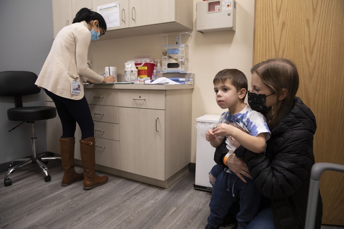 FILE - Ilana Diener holds her son, Hudson, 3, during an appointment for a Moderna COVID-19 vaccine trial in Commack, N.Y. on Nov. 30, 2021. On Thursday, April 28, 2022, Moderna asked U.S. regulators to authorize low doses of its COVID-19 vaccine for children younger than 6, a long-awaited move toward potentially opening shots for millions of tots by summer.  (Emma H. Tobin)