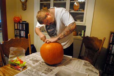 
Curtis Wilkes starts his pumpkin by cutting a hole in the top and removing the seeds and pulp.
 (The Spokesman-Review)