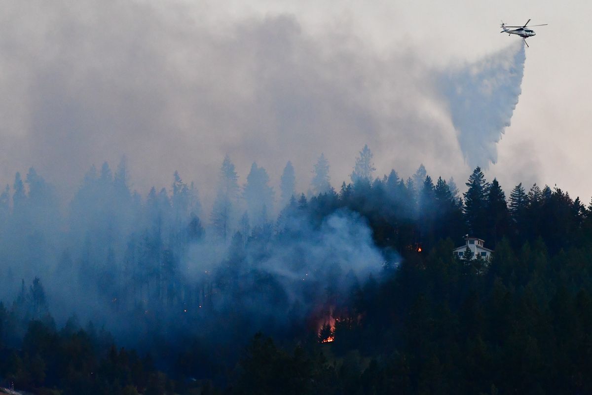 Crews work to suppress a wildfire as it approaches a home on Sunday north of Spokane. Early reports indicate the fire started off of Hazard Road late Sunday afternoon.  (Tyler Tjomsland/The Spokesman-Review)