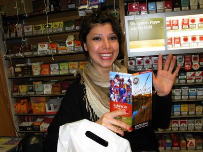 Barfen Parlak displays Spokane brochures, printed in German, at a shop called the Kiosk in Cologne, Germany.  (Doug Clark / The Spokesman-Review)