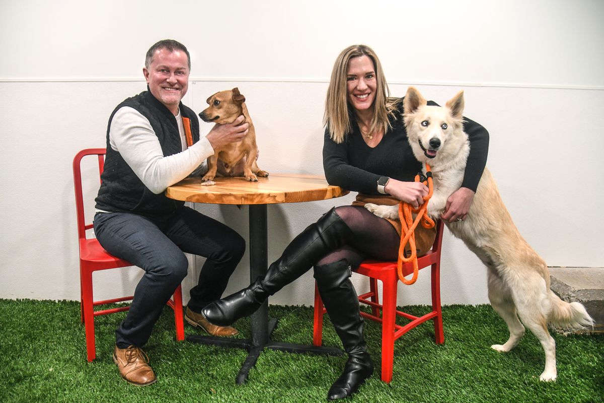Bark, a Rescue Pub owners Josh Wade, with Chunk, a 1½-year-old Doxie mix, and Katie Holmes, with Harley, a 3-year-old husky mix, have closed the year with the 300th adoption at their new restaurant that includes a rescue shelter.  (Dan Pelle/The Spokesman-Review)