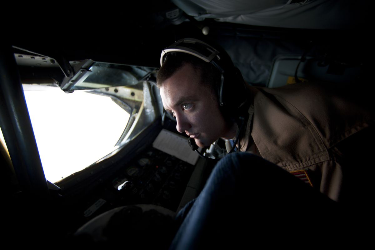 Boom operator Aaron McLaughlin keeps a watchful eye on an F/A-18E Super Hornet fighter plane being refueled off the starboard wing of a KC-135R Stratotanker. 