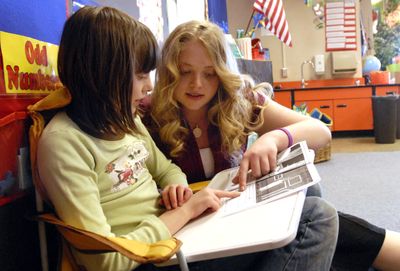 Lauren Puhek, of Central Valley High School, helps second-grader Josie Scribner with a reading exercise  Wednesday in a quiet corner at Greenacres Elementary School. Puhek, a WAVE scholarship recipient, will be the first in her family to attend college.    (J. BART RAYNIAK / The Spokesman-Review)