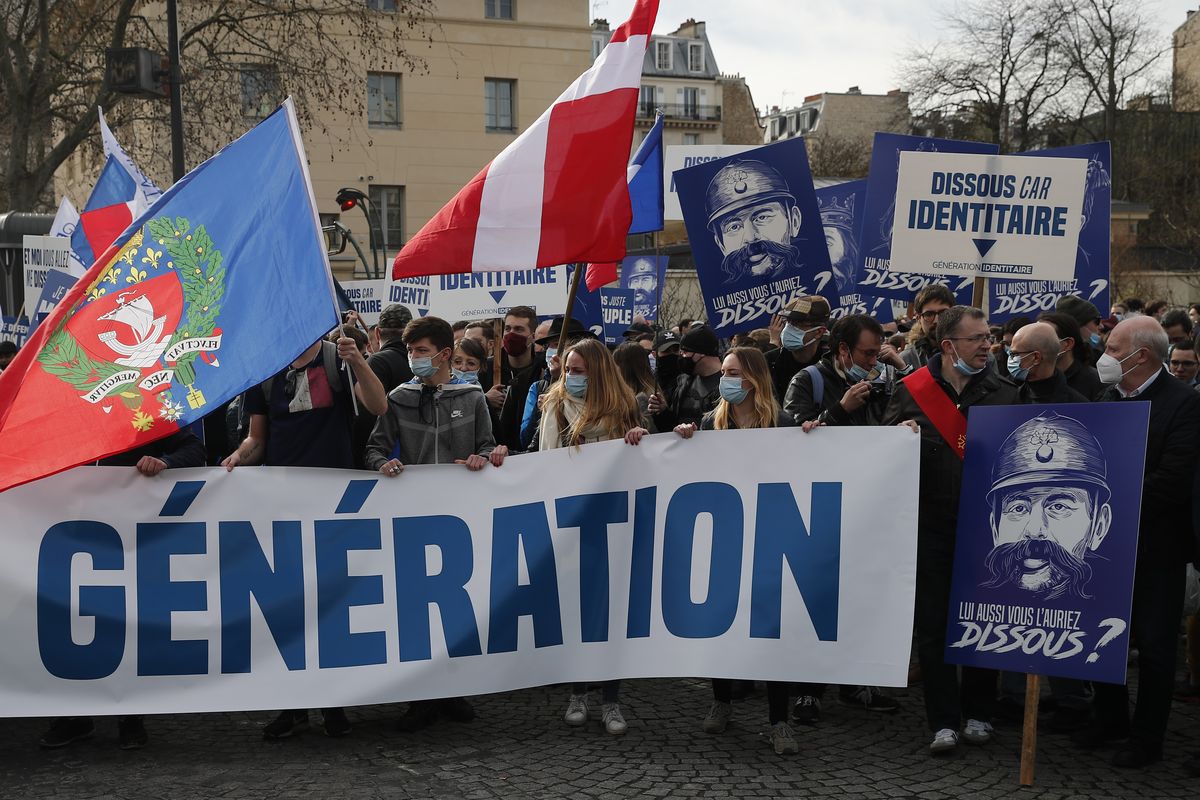 FILE - In this Feb.20, 2021 file photo, supporters of the group Generation Identity hold a banner reading "Man does not dissolve a generation" during a demonstration in Paris. French Interior Minister Gerald Darmanin announced Wednesday the dissolution of the anti-migrant group Generation Identity during a Cabinet meeting on the ground it is encouraging discrimination in the country.  (Francois Mori)