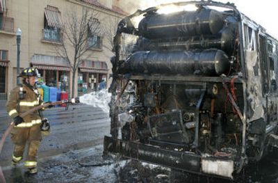 A Boise fireman pours water on the bus that caught fire Thursday, sending flames nearly three stories into the air.
(The Spokesman-Review)