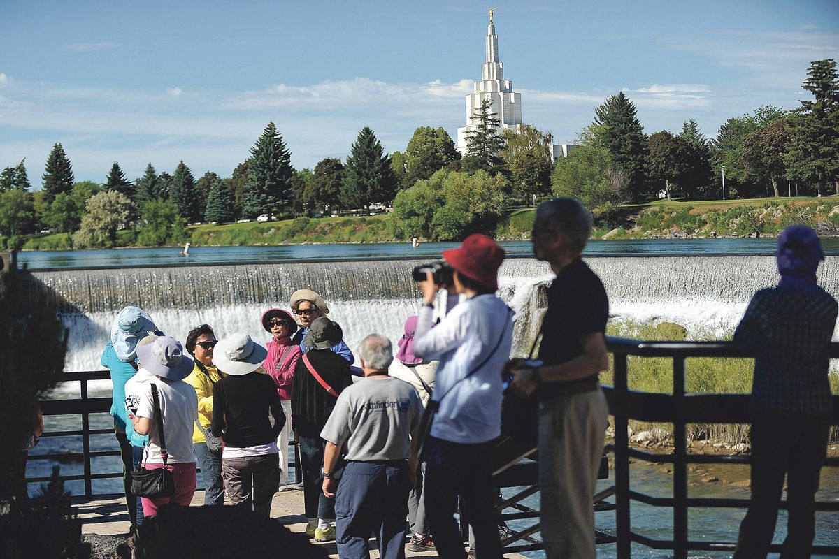 Chinese tourists returning from Yellowstone National Park take pictures of the falls June 20 on the greenbelt. Idaho Falls has seen a fast-growing number of Chinese tour groups spending time in the city in the last several years. (Pat Sutphin / Idaho Falls Post Register)