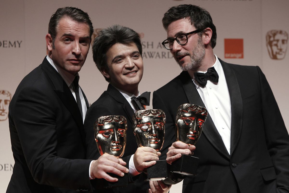 Actor Jean Dujardin, producer Thomas Langmann and director Michel Hazanavicius show off their awards for the “The Artist.” (Associated Press)