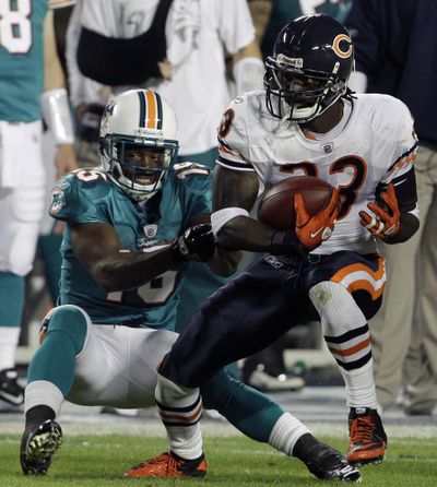 Miami receiver Davone Bess, left, tackles Charles Tillman after the Chicago cornerback’s pickoff.  (Associated Press)