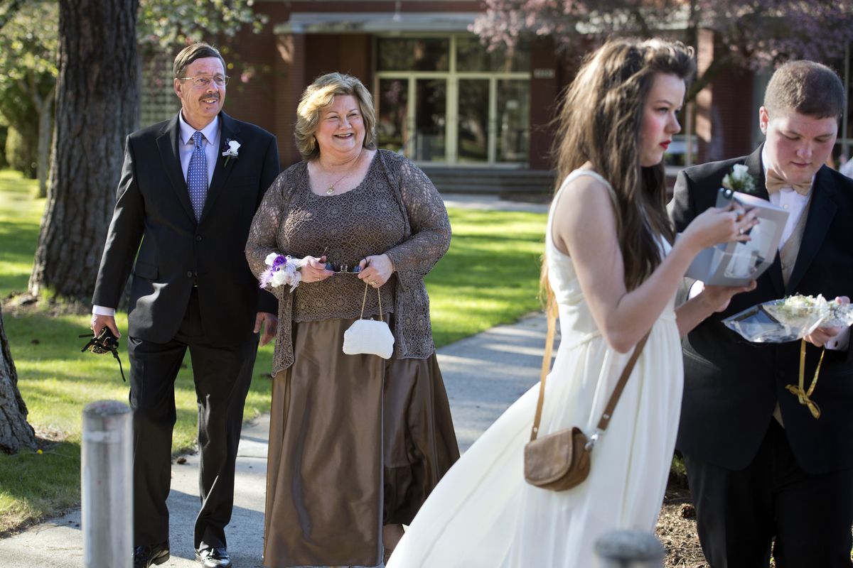 Dave Snyder and Barbara Kolbet pass a group of North Central High School students waiting to have pictures taken before the start of the school’s prom Saturday at Mukogawa Fort Wright Institute. Barbara said, “We put the senior in senior prom.” (Dan Pelle)