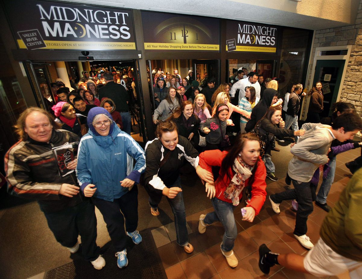 FILE -In this  Friday, Nov. 23, 2012, file photo, Black Friday shoppers pour into the Valley River Center mall for the Midnight Madness sale, in Eugene, Ore. U.S. shoppers hit stores and websites at record numbers over the four-day Thanksgiving weekend, according to a survey released by the National Retail Federation on Sunday. They were attracted by retailers
