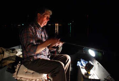 
Loon Lake resident and angler Red Crass beats the heat by still-fishing at night for kokanee using battery- powered lights on his small boat. 
 (Rich Landers / The Spokesman-Review)
