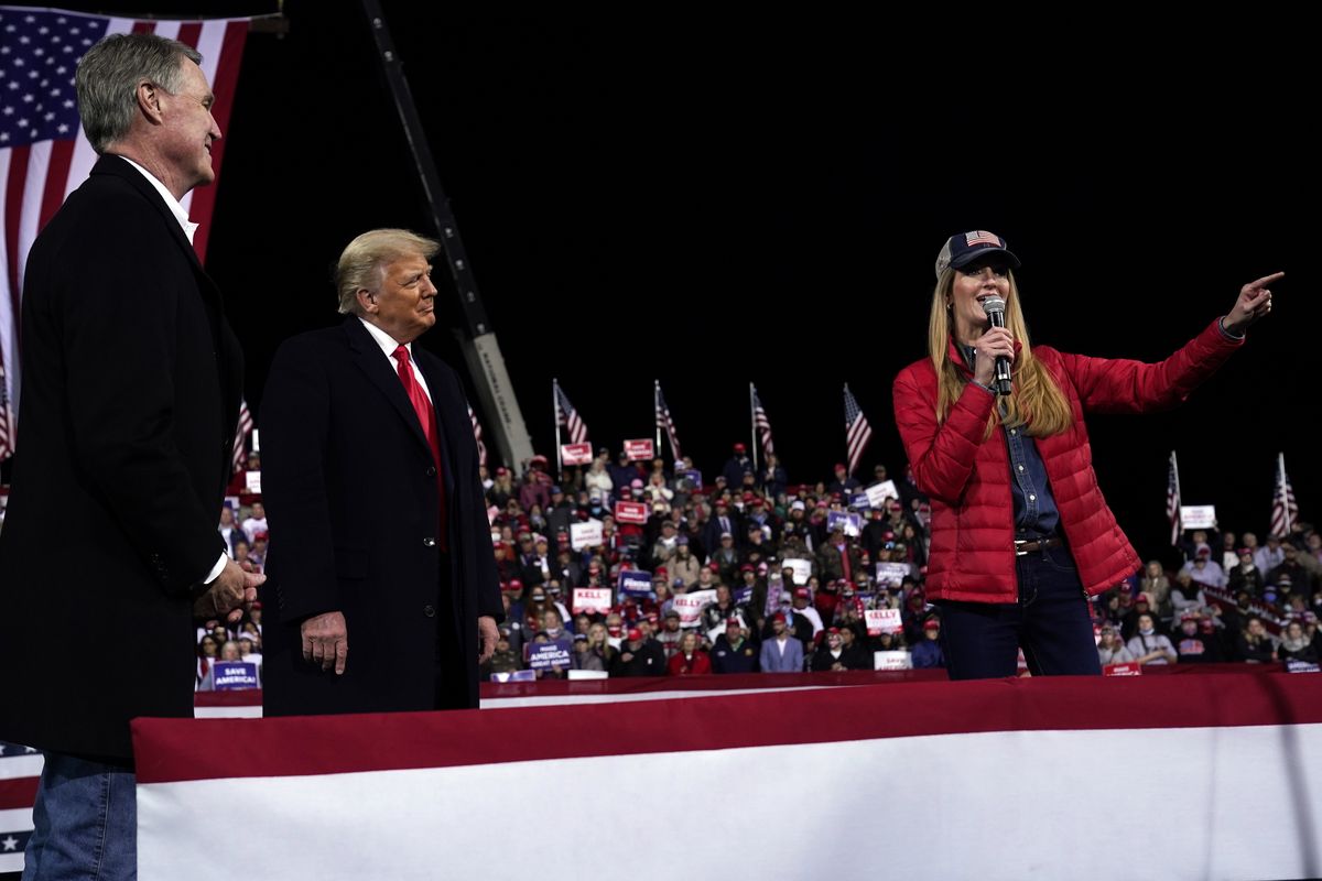 FILE - In this Dec. 5, 2020, file photo Sen. Kelly Loeffler, R-Ga., speaks as President Donald Trump and Sen. David Perdue, R-Ga., listen at a campaign rally at Valdosta Regional Airport, Saturday, Dec. 5, 2020, in Valdosta, Ga. Many Republican voters in Georgia are angry; certain that widespread voter fraud — claims of which are baseless — cost President Donald Trump the election. Most Republican voters in the state interviewed said they were prepared to put their skepticism aside to vote for Perdue and Loeffler in their races against Democrats Jon Ossoff and Raphael Warnock.  (Evan Vucci)
