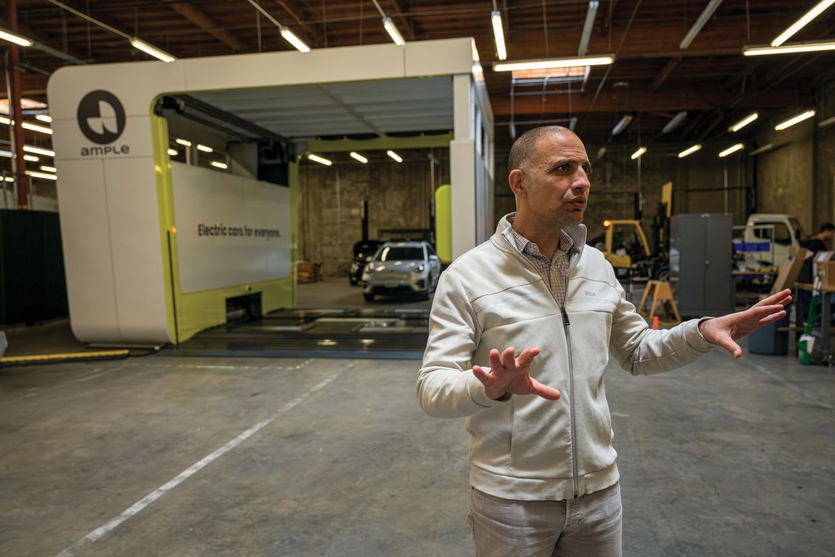 Khaled Hassounah, co-founder and CEO of startup Ample, stands near the company’s EV battery-swap station demo in its San Francisco warehouse.  (David Paul Morris/Bloomberg)