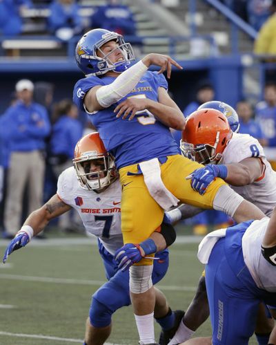 San Jose State quarterback Kenny Potter throws under pressure from Boise State linebacker Joe Martarano, left, and defensive lineman Kamalei Correa during the second half of the Broncos’ 40-23 win over the Spartans in San Jose, Calif.