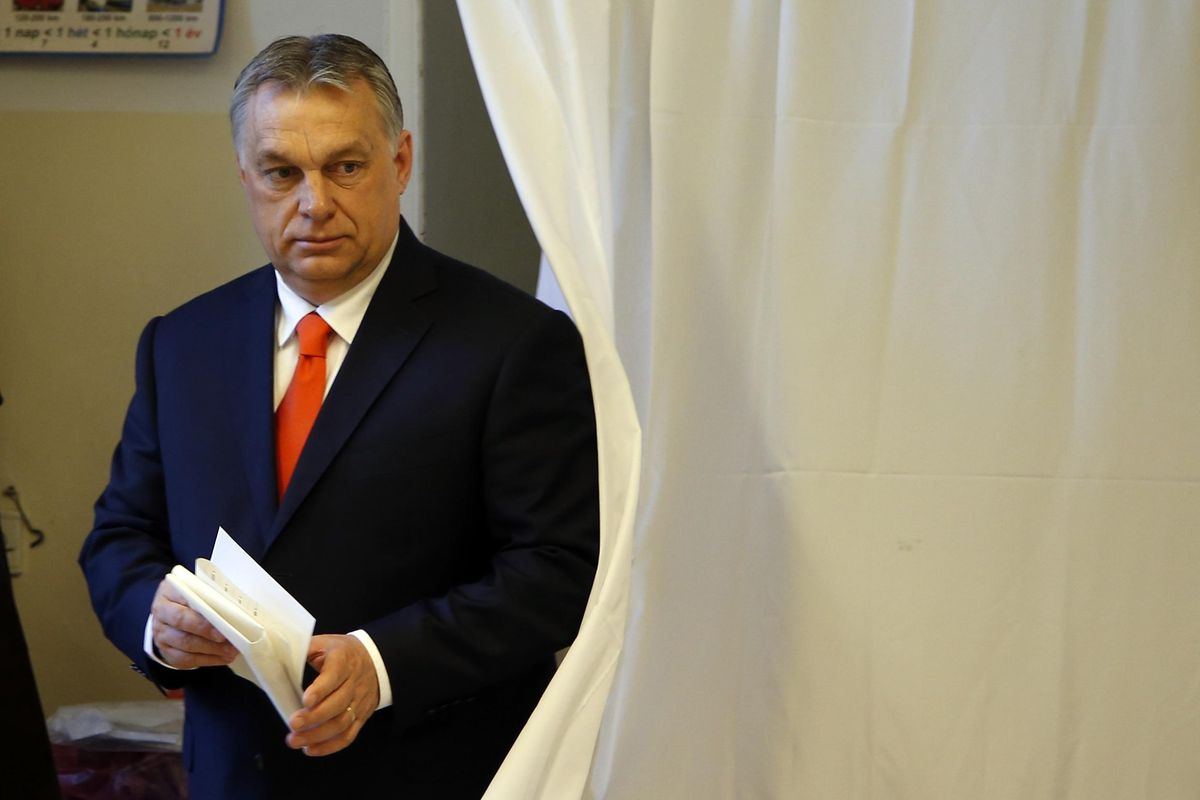Hungary’s Prime Minister Viktor Orban carries his ballot at a polling station in Budapest, Hungary, Sunday, April 8, 2018. (Darko Vojinovic / Associated Press)