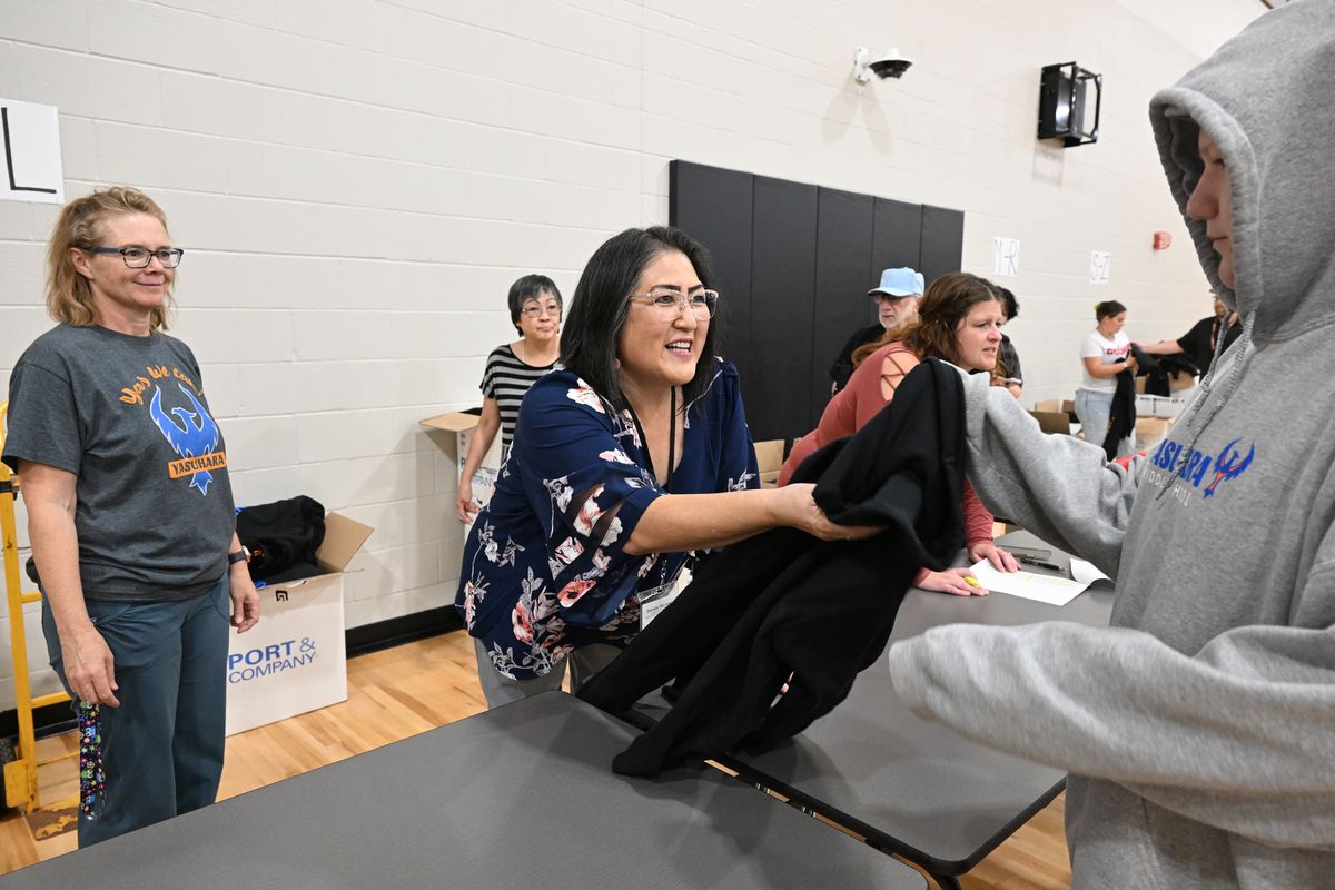 Patty Marinos, center, hands out new sweatshirts to student at Denny Yasuhara Middle School in Spokane Friday, Sept. 15, 2023.   (Jesse Tinsley/The Spokesman-Review)