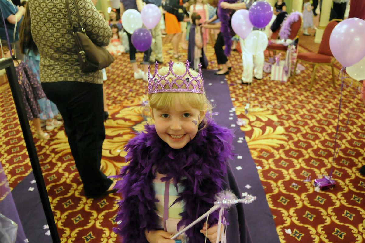 Elizabeth Carter, 51/2, stops at a mirror and smiles at herself after walking  the purple carpet during the activities at the Spokane Lilac Festival Association Royal Tea Party. (J. BART RAYNIAK)
