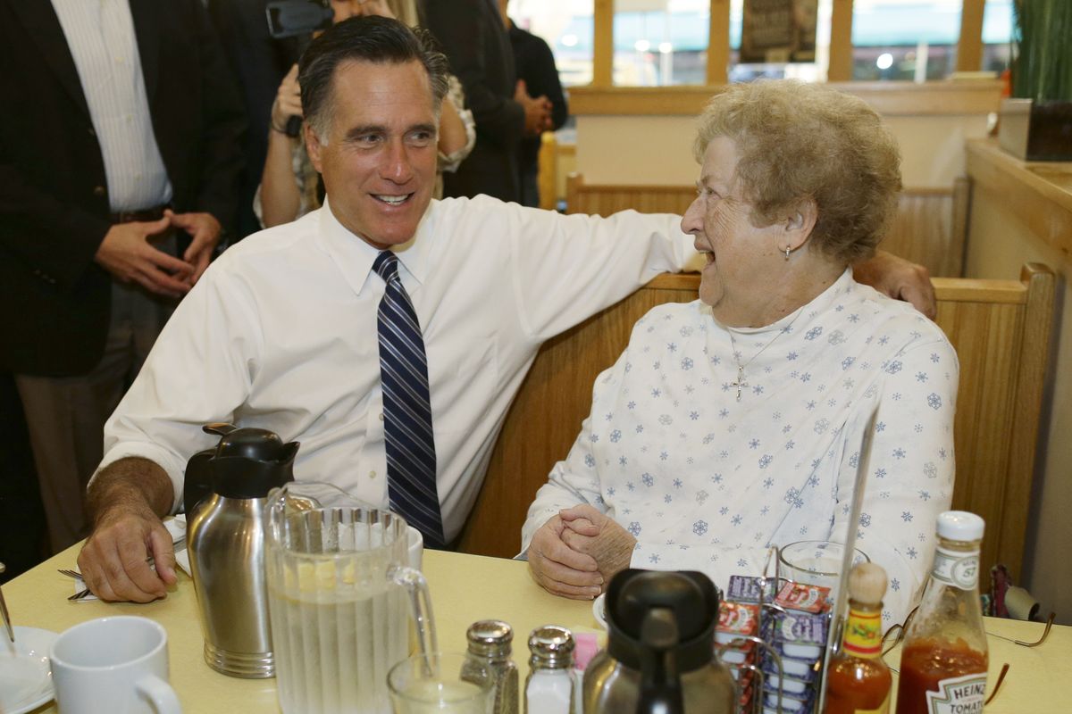 Republican presidential candidate, former Massachusetts Gov. Mitt Romney sits and talks to a customer as he makes an unscheduled stop at First Watch cafe in Cincinnati, Ohio, Thursday, Oct. 25, 2012. (Charles Dharapak / Associated Press)