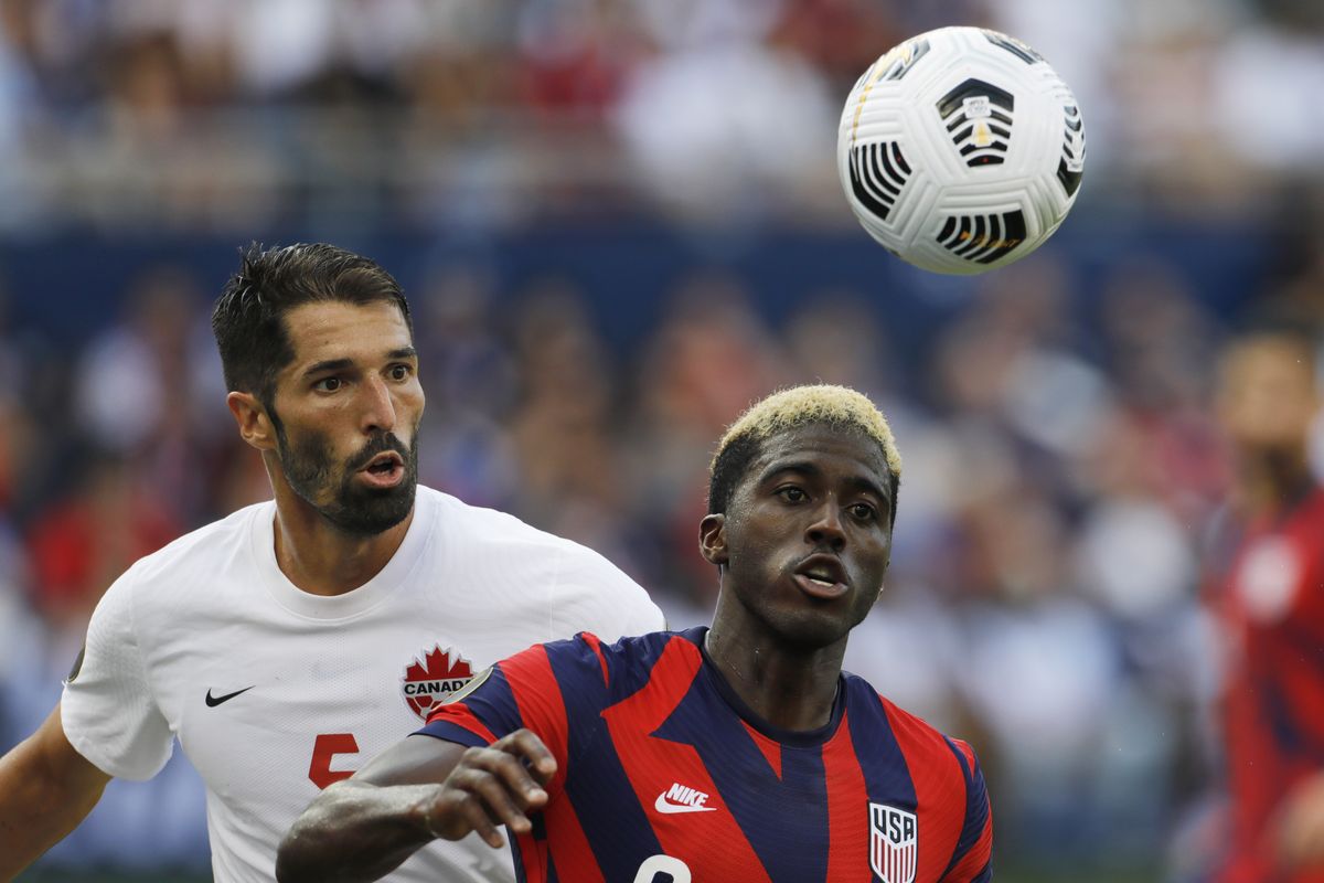 Canada defender Steven Vitoria (5) and U.S. forward Gyasi Zardes (9) chase down the ball during the second half of a CONCACAF Gold Cup soccer match in Kansas City, Kan., Sunday, July 18, 2021.  (Colin E. Braley)