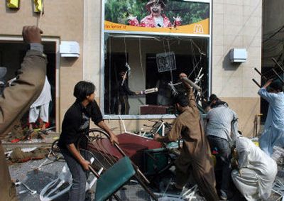 
Pakistani protesters attack  a McDonald's   in Lahore on Tuesday. Thousands rampaged through two Pakistani cities,  setting fire to Western businesses and a government building. 
 (Associated Press / The Spokesman-Review)