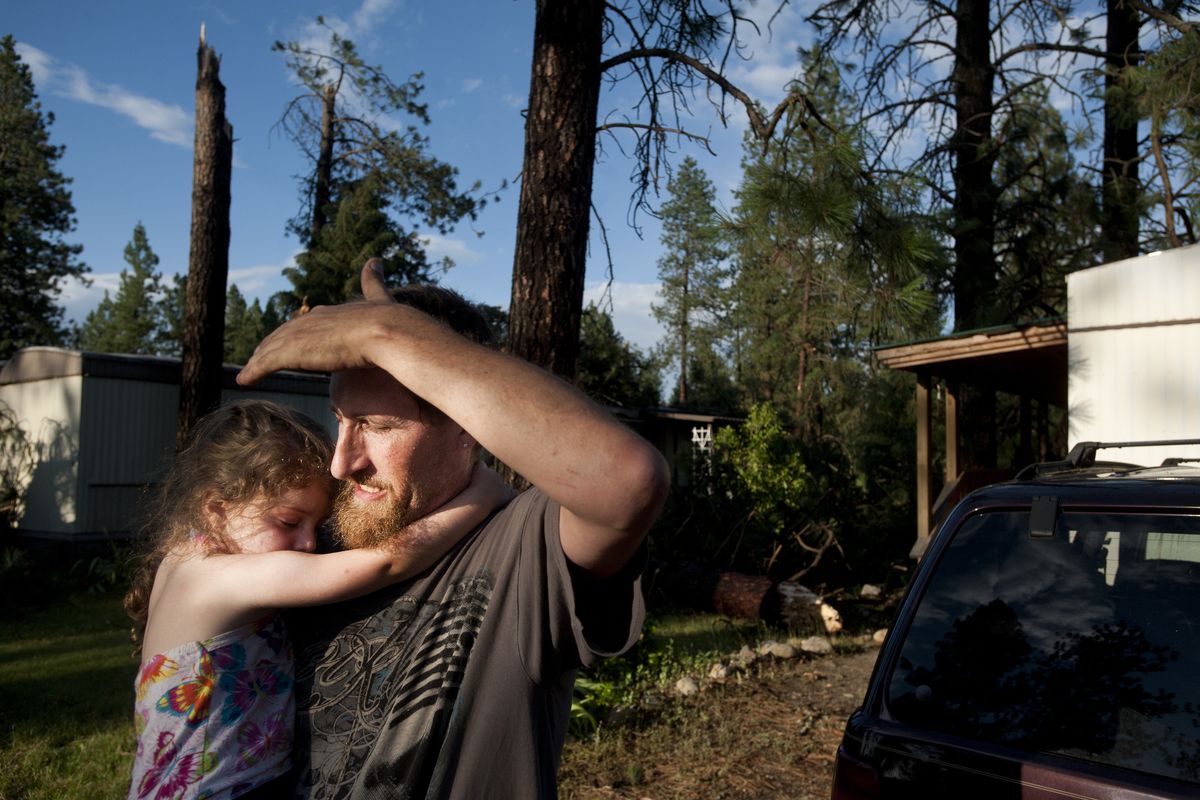 Riverside Village resident Alva Lucas holds Ireland, 3, the granddaughter of his girlfriend, Gladys Wallin, after their home was destroyed and they were nearly struck by falling trees Wednesday. “My car is gone and so is my home, but I made it out with what counts,” he said. (Tyler Tjomsland)