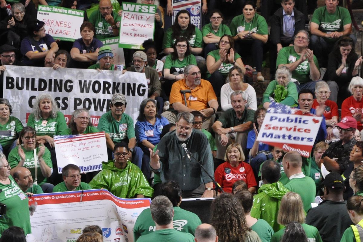 Washington State Labor Council President Jeff Johnson (center, at microphone) urges state workers to vote for candidates who value them as “social infrastructure.” (Jim Camden / The Spokesman-Review)